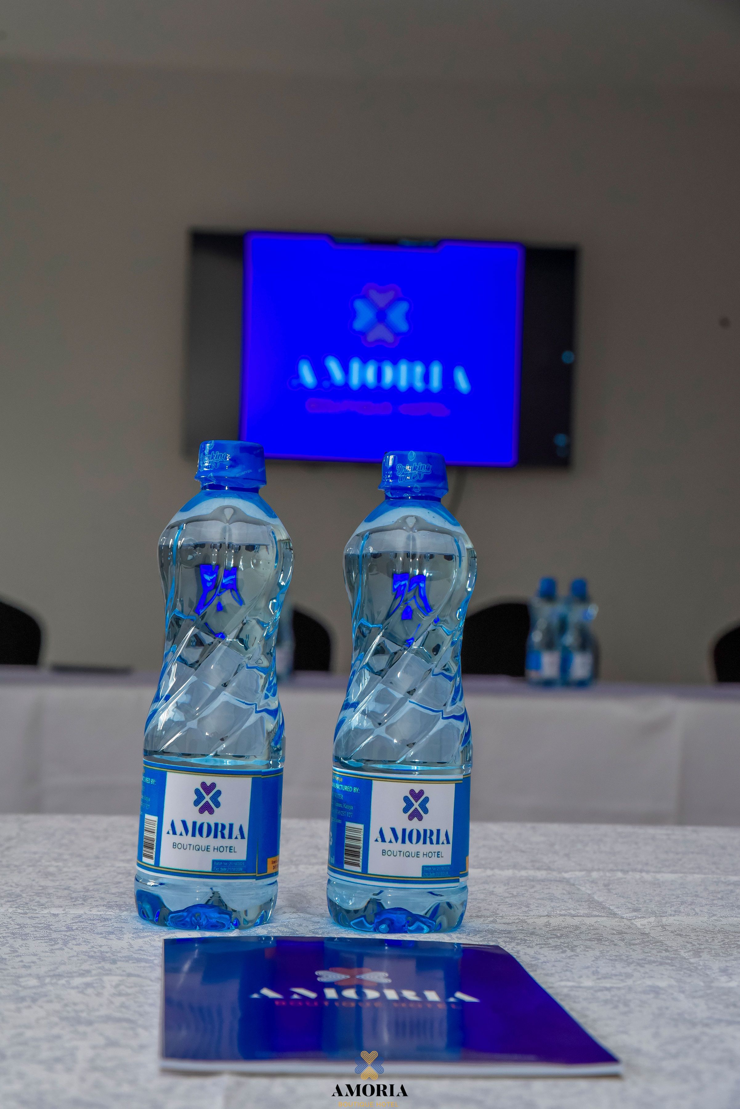 Amoria-branded water bottles on a conference table