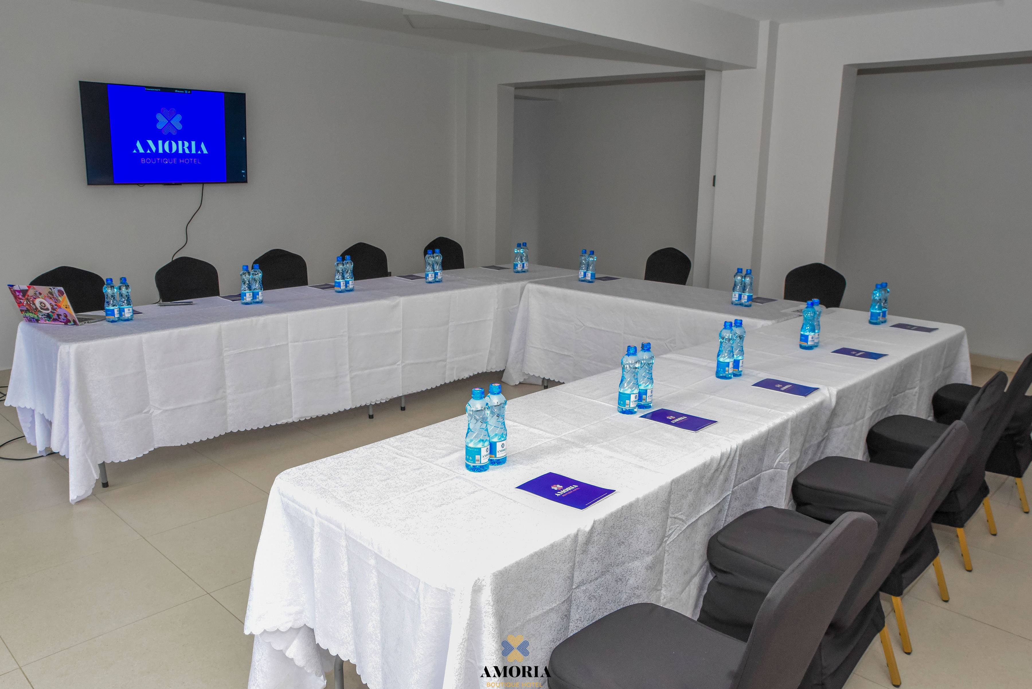 Conference hall with U-shaped tables, flipchart and garden windows