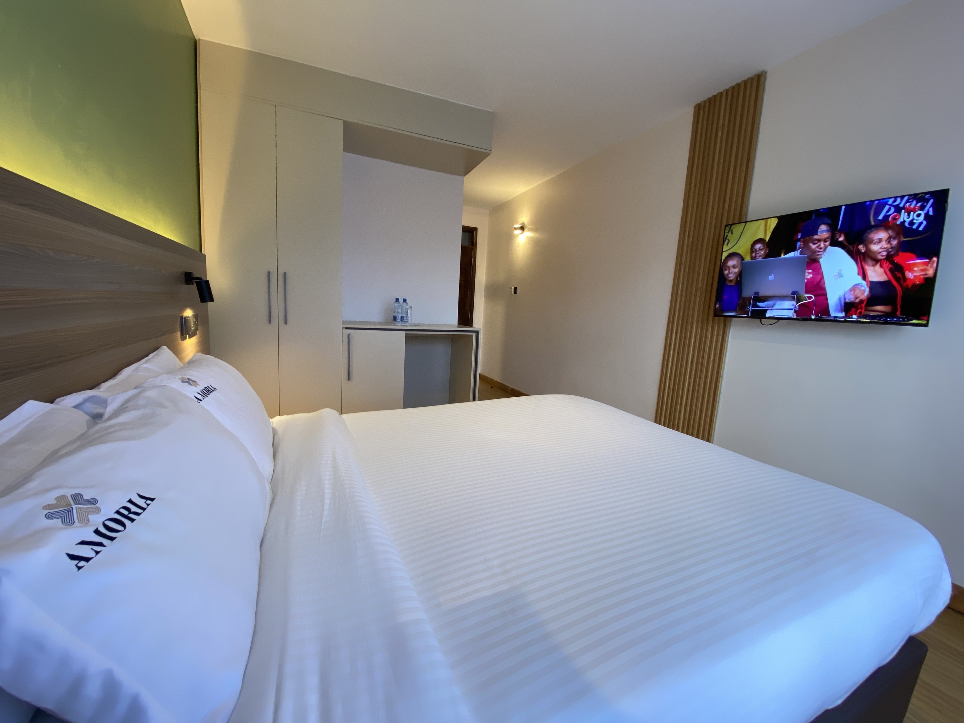 Two white bathrobes embroidered with the Amoria mark laid out on a bed