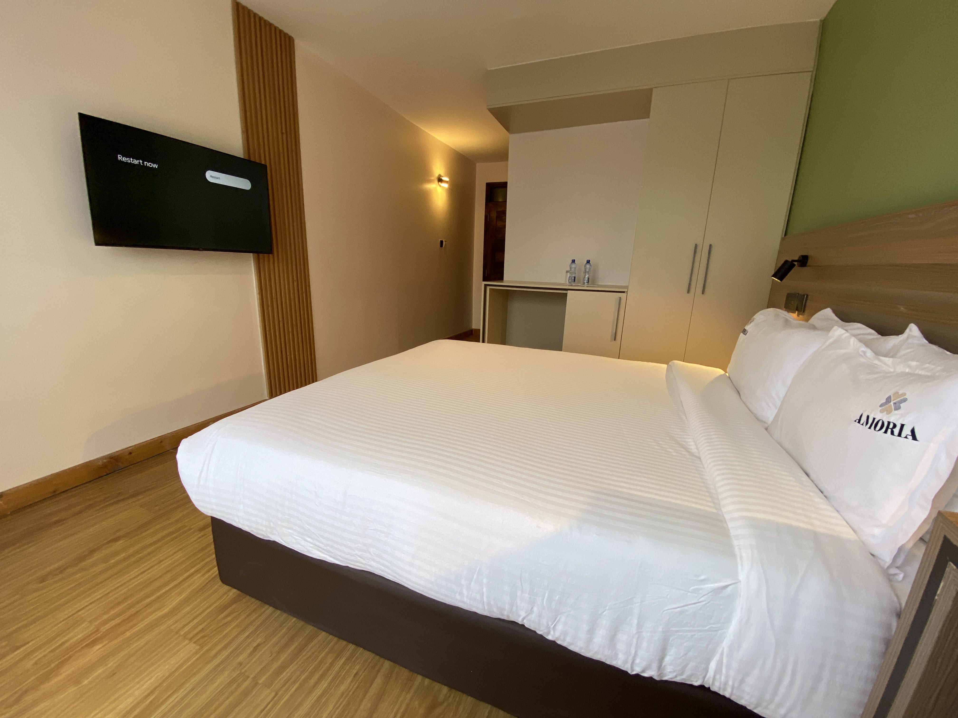 Deluxe room wardrobe and luggage nook beside the slatted-wood TV panel