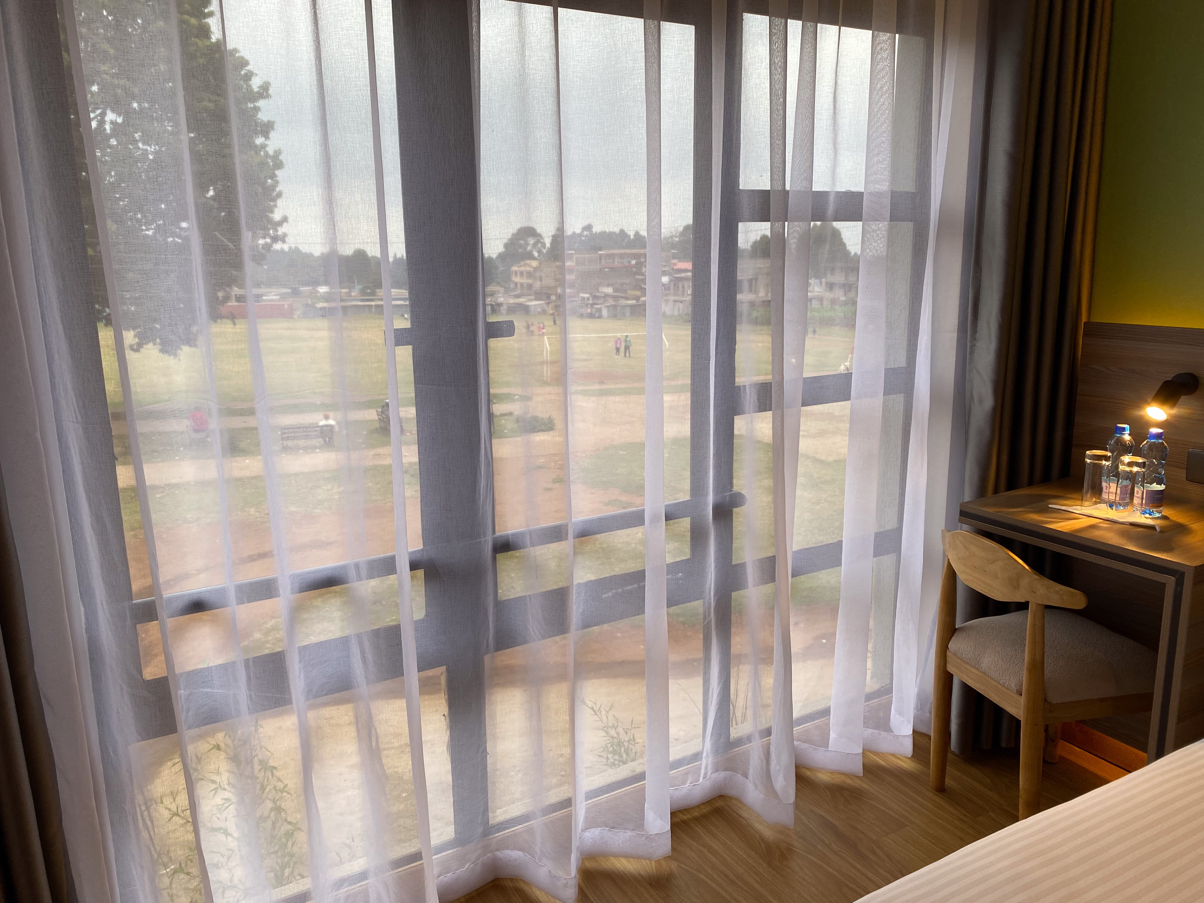 The Standard room's writing desk and chair by the window, the lawns beyond the sheer curtains