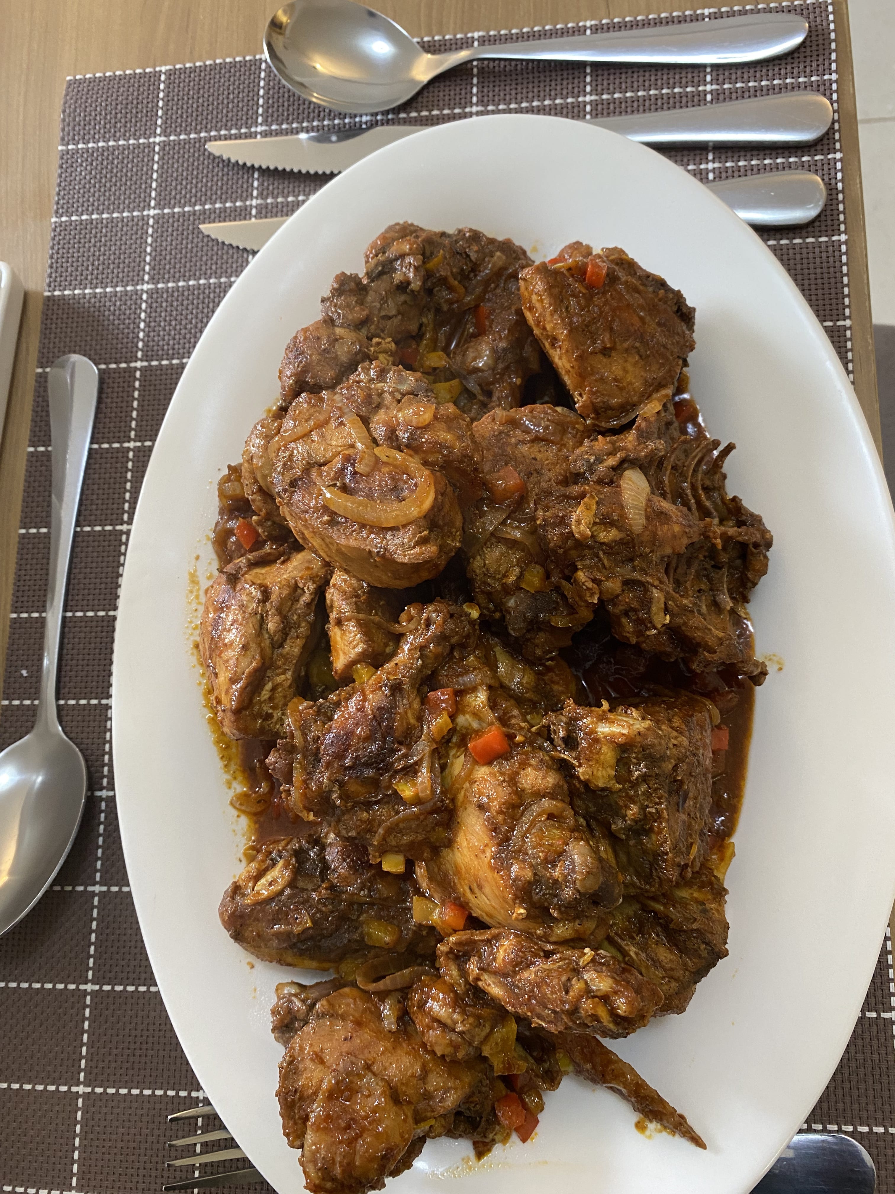 Chicken wet fry in a rich onion-tomato gravy on a white sharing platter