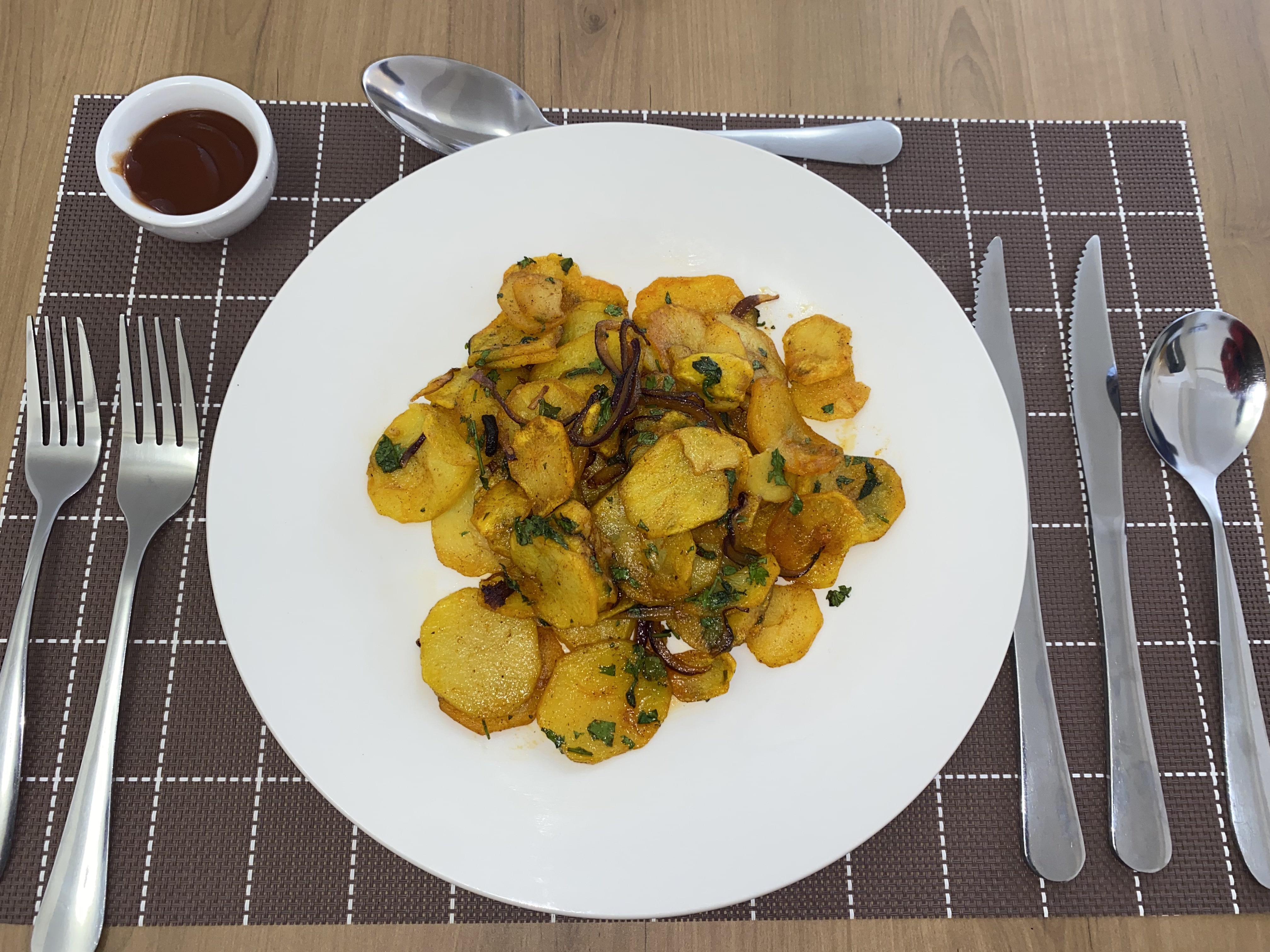 Golden pan-fried potato rounds finished with herbs and red onion