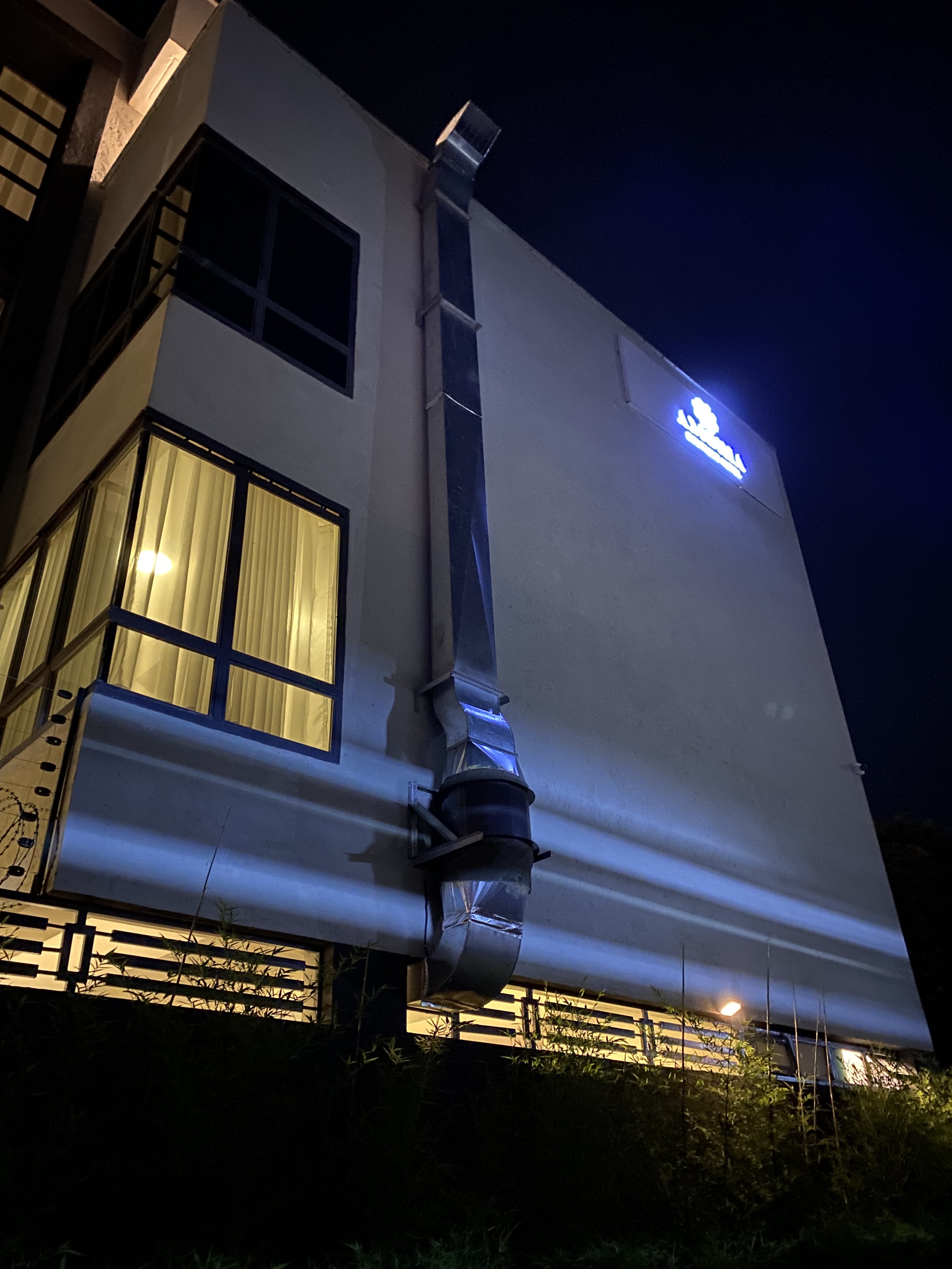 The Amoria facade at night, its logo sign lit above glowing curtained windows
