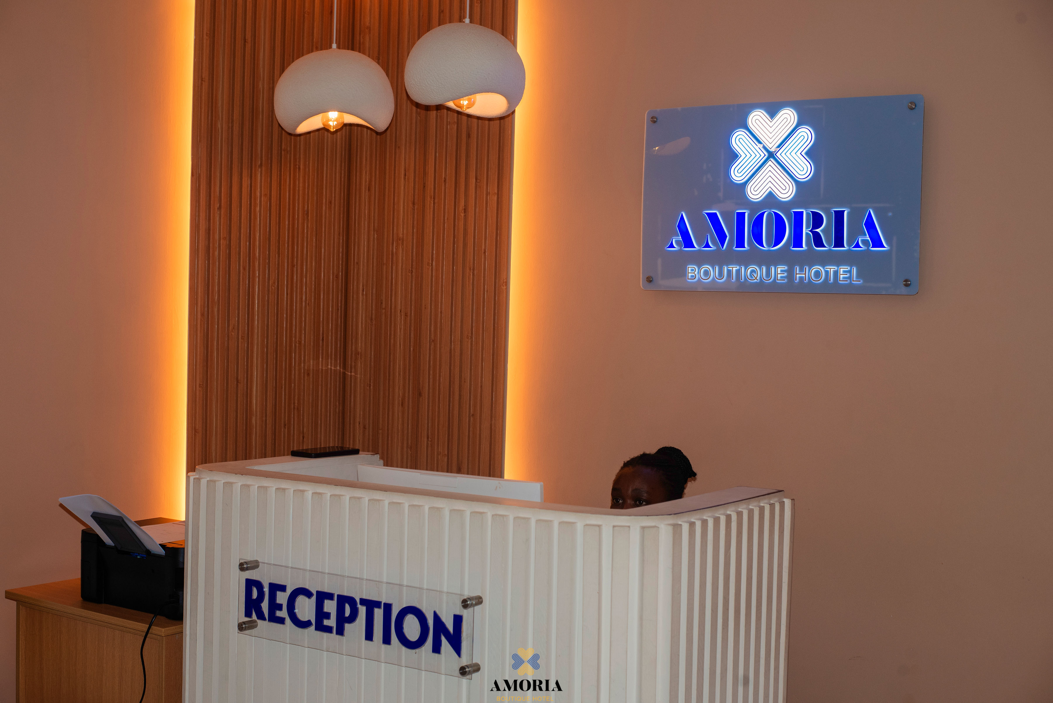 The Amoria Boutique Hotel sign glowing above the reception desk